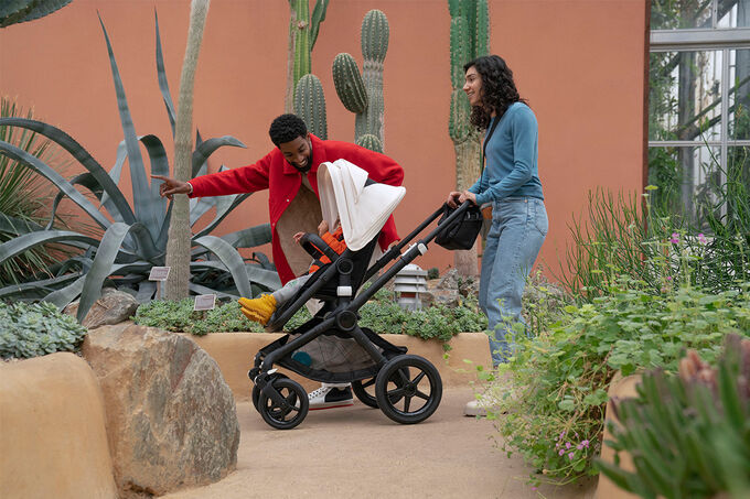 Parents pushing their baby in a stroller